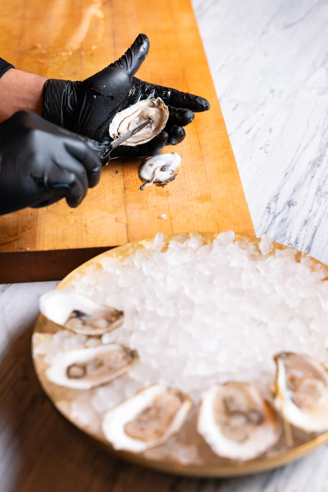Chef opening oysters on ice