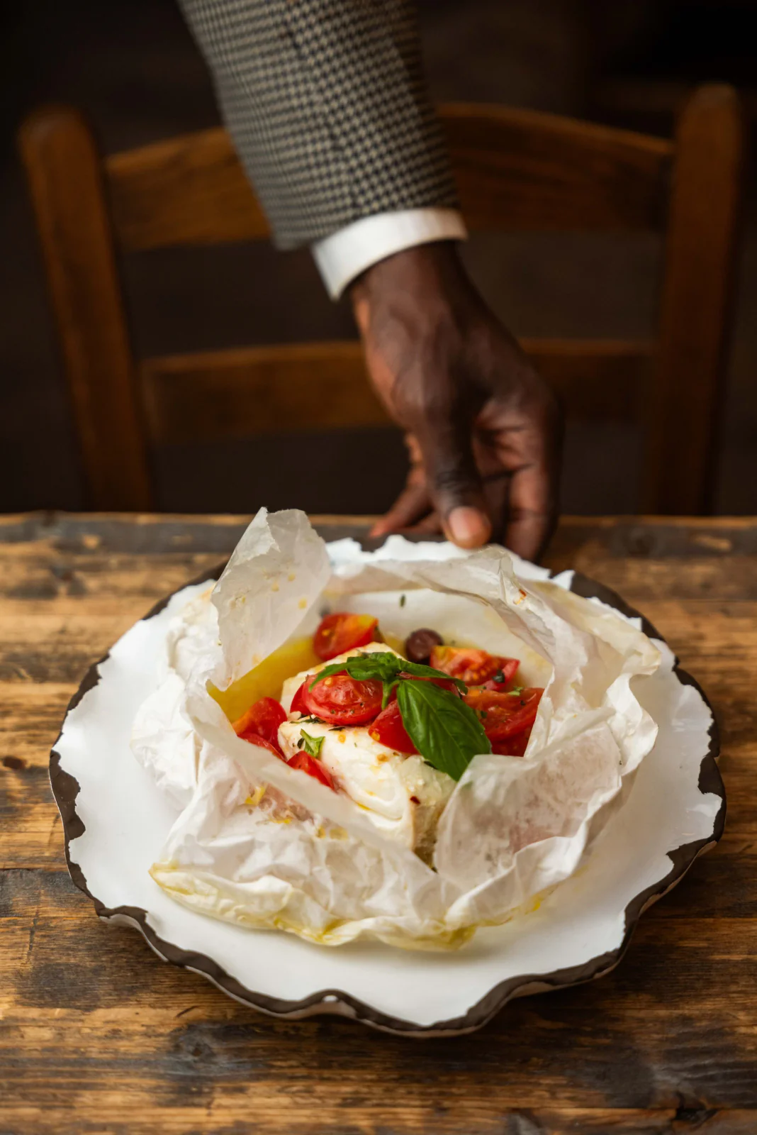 Fish served in parchment with tomato and basil